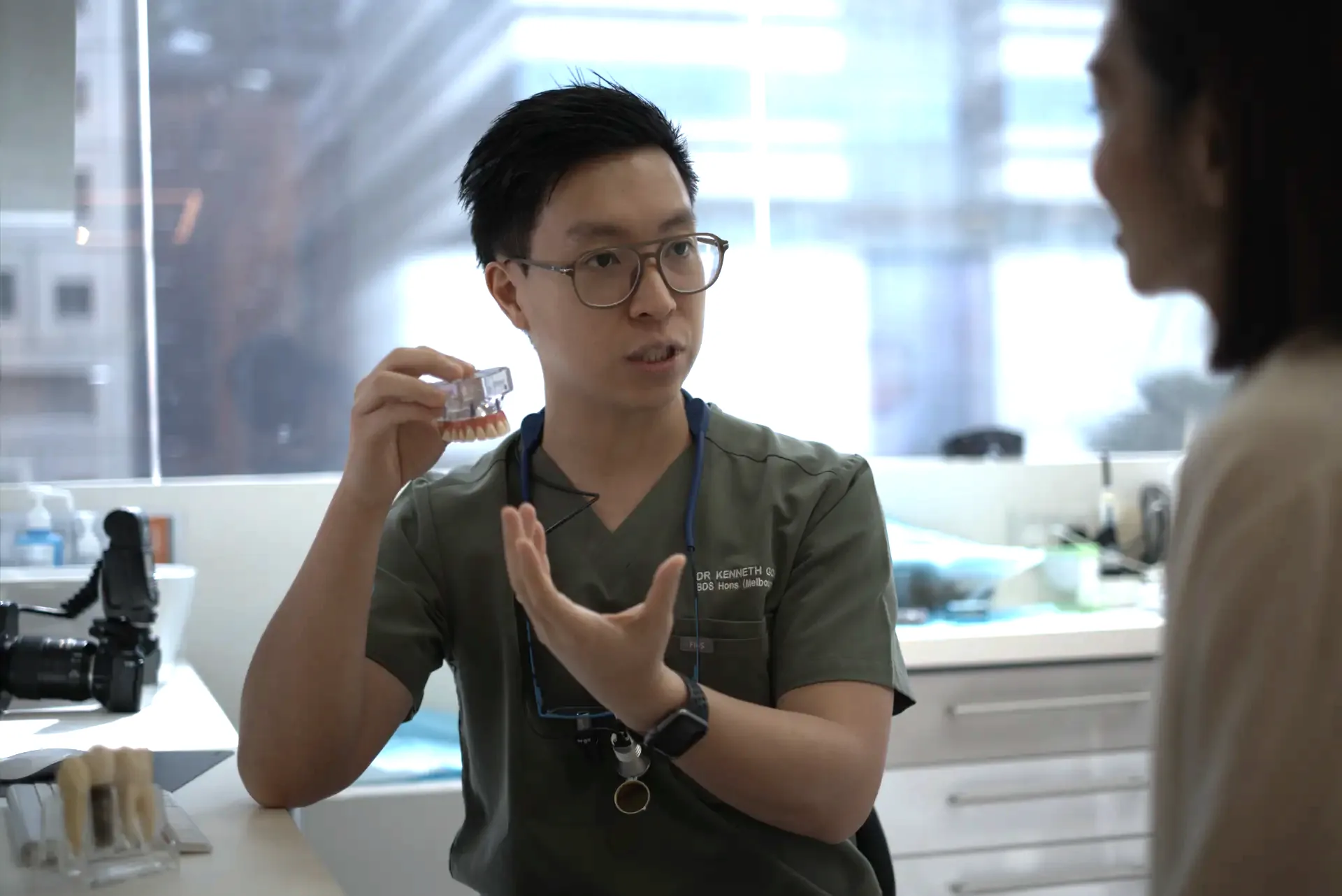 Dr Kenneth Goh in conversation, explaining a treatment consideration with a dental model