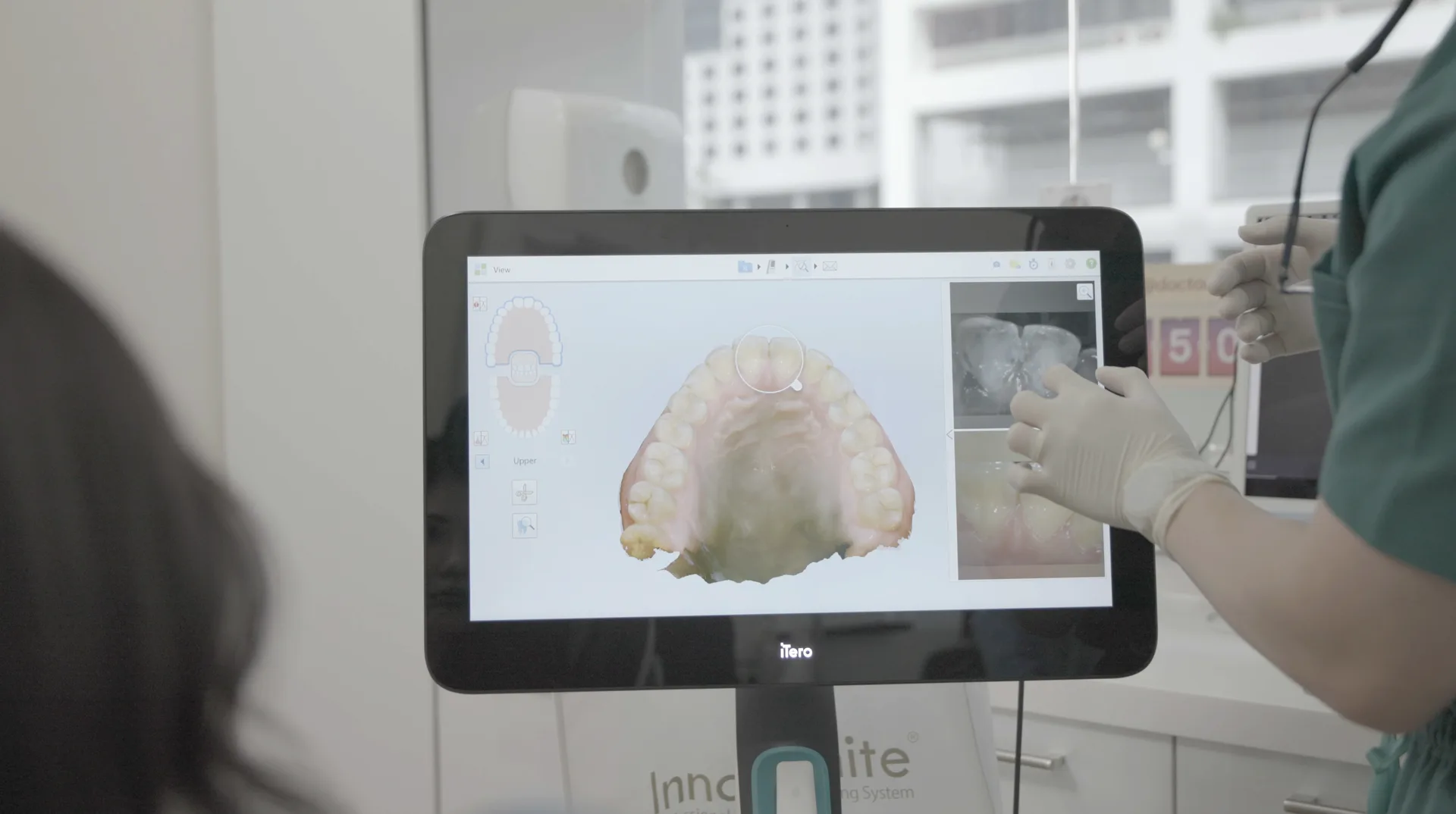 A dentist reviewing a patient's digital intraoral scan on screen at Orchard Scotts Dental, Singapore
