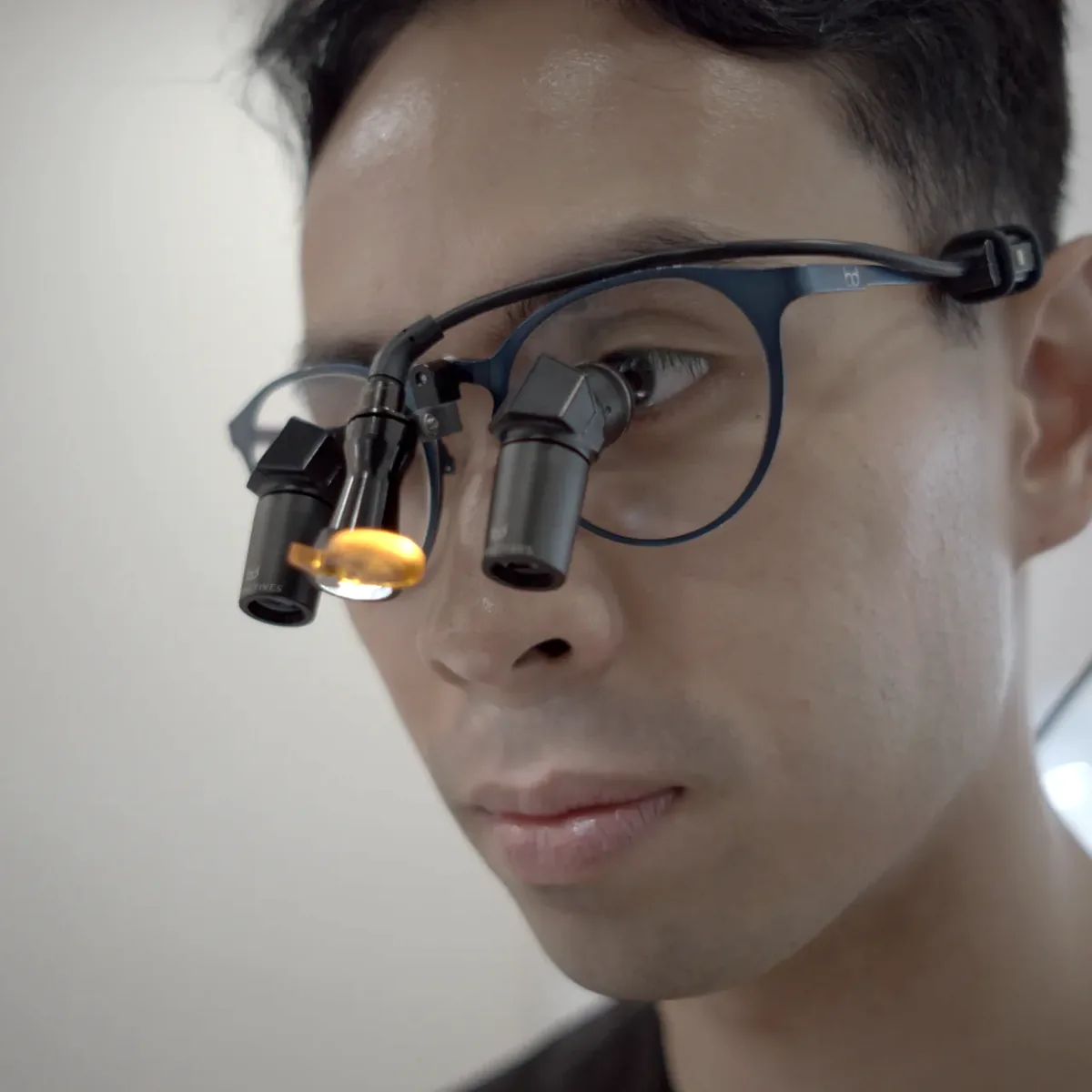 Dr. Martin Nguyen, Associate Dentist at Orchard Scotts Dental, examining closely with loupes